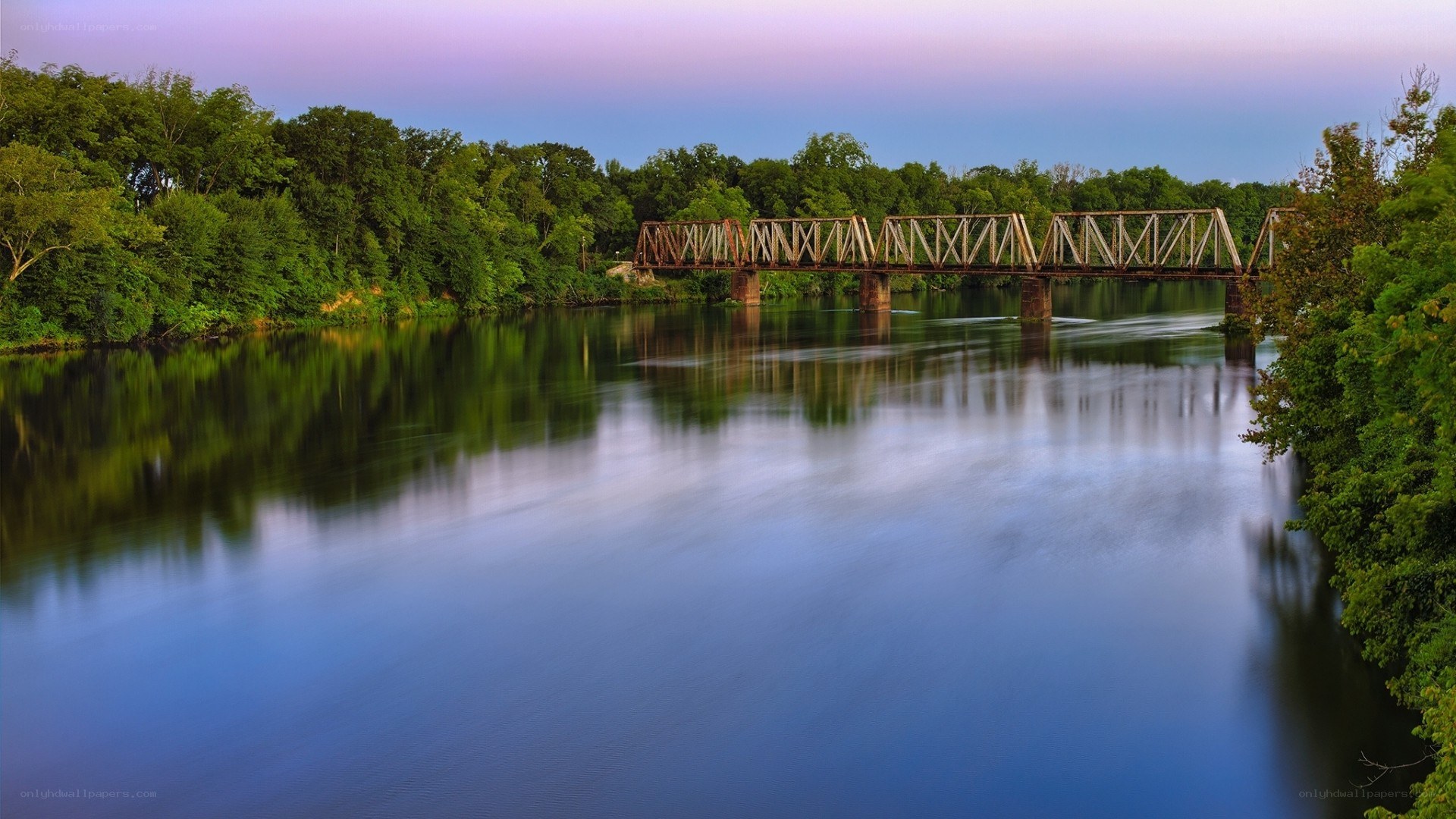 Bridge over calm river at dusk