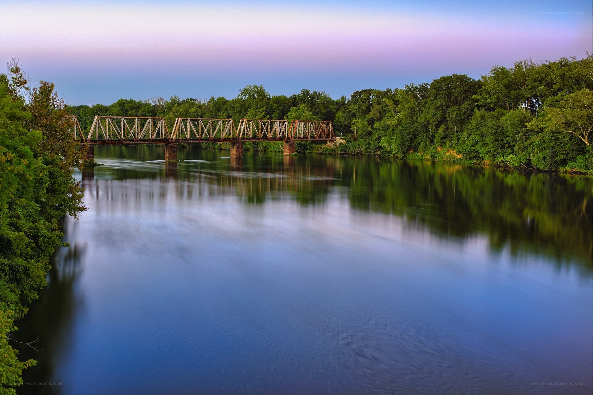 Bridge over calm river at dusk