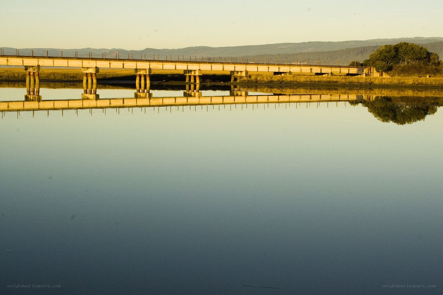 Bridge over calm water at sunset
