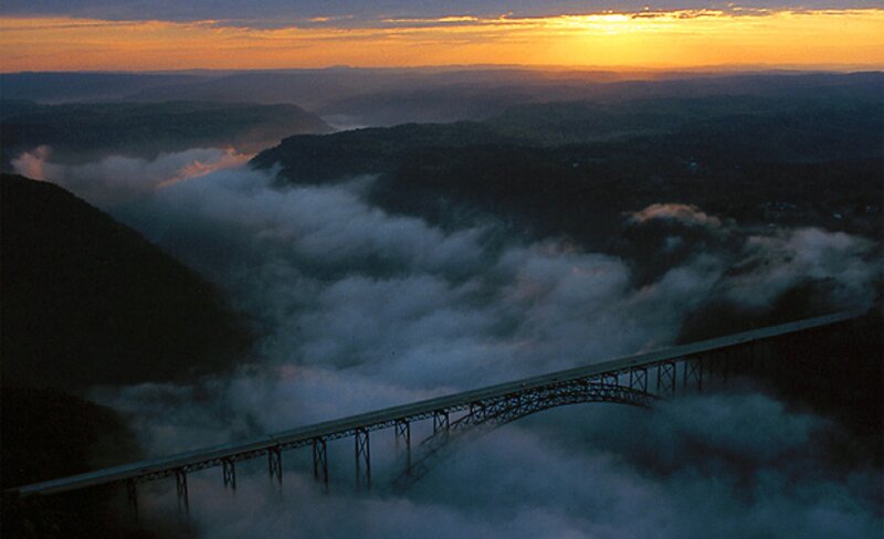 Bridge over foggy valley at sunrise