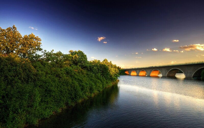 Bridge over river at sunset