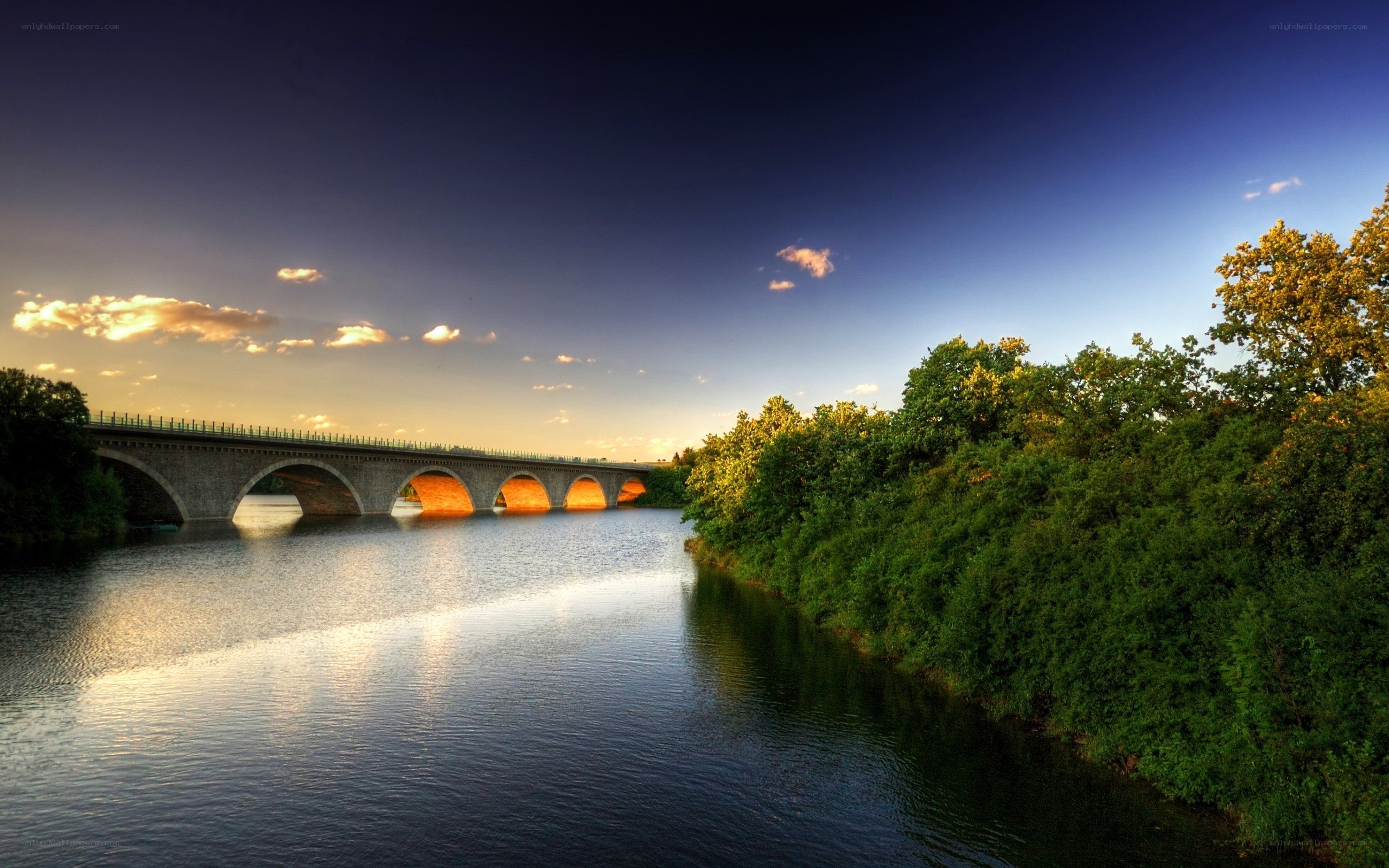 Bridge over river at sunset