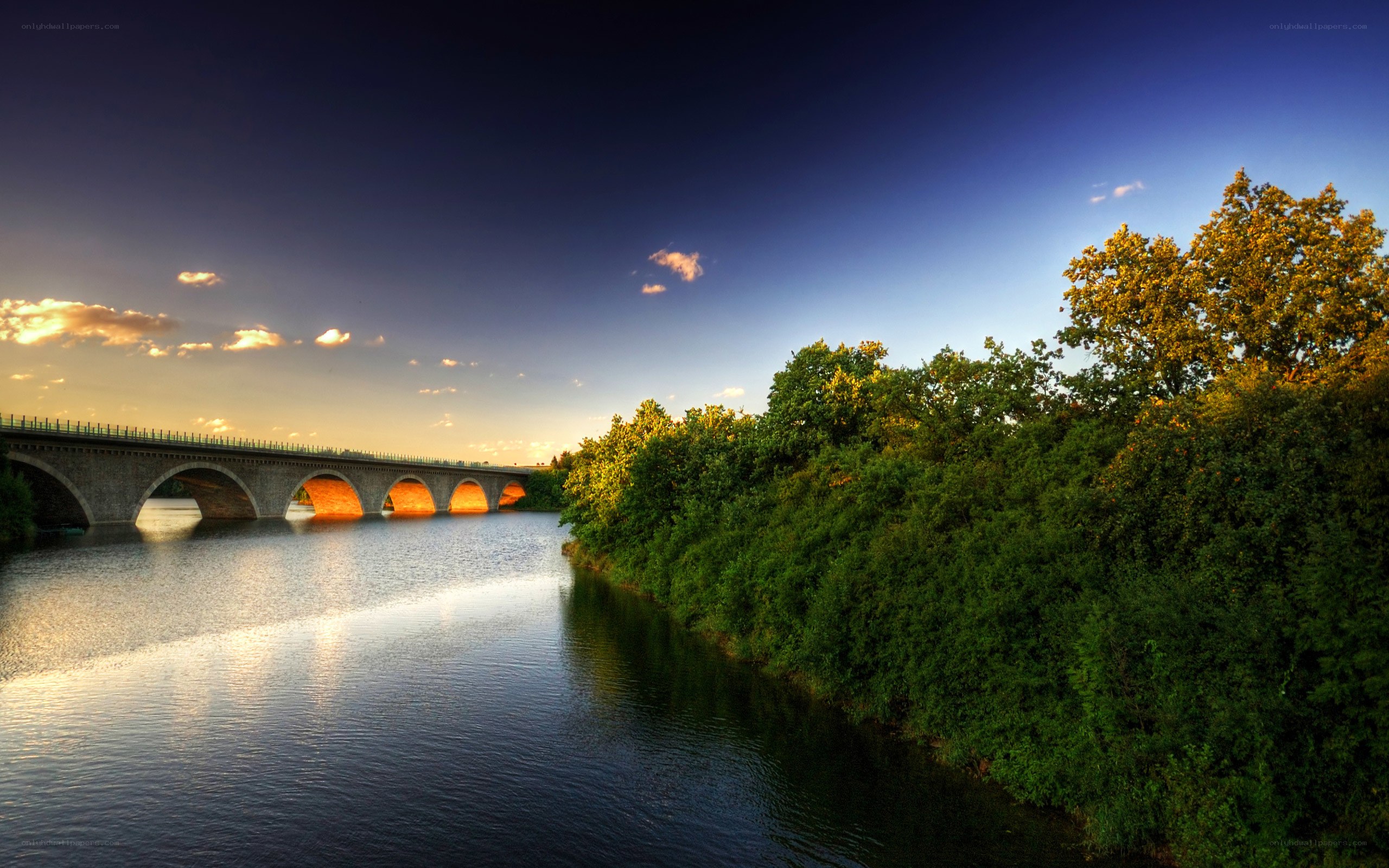 Bridge over river at sunset