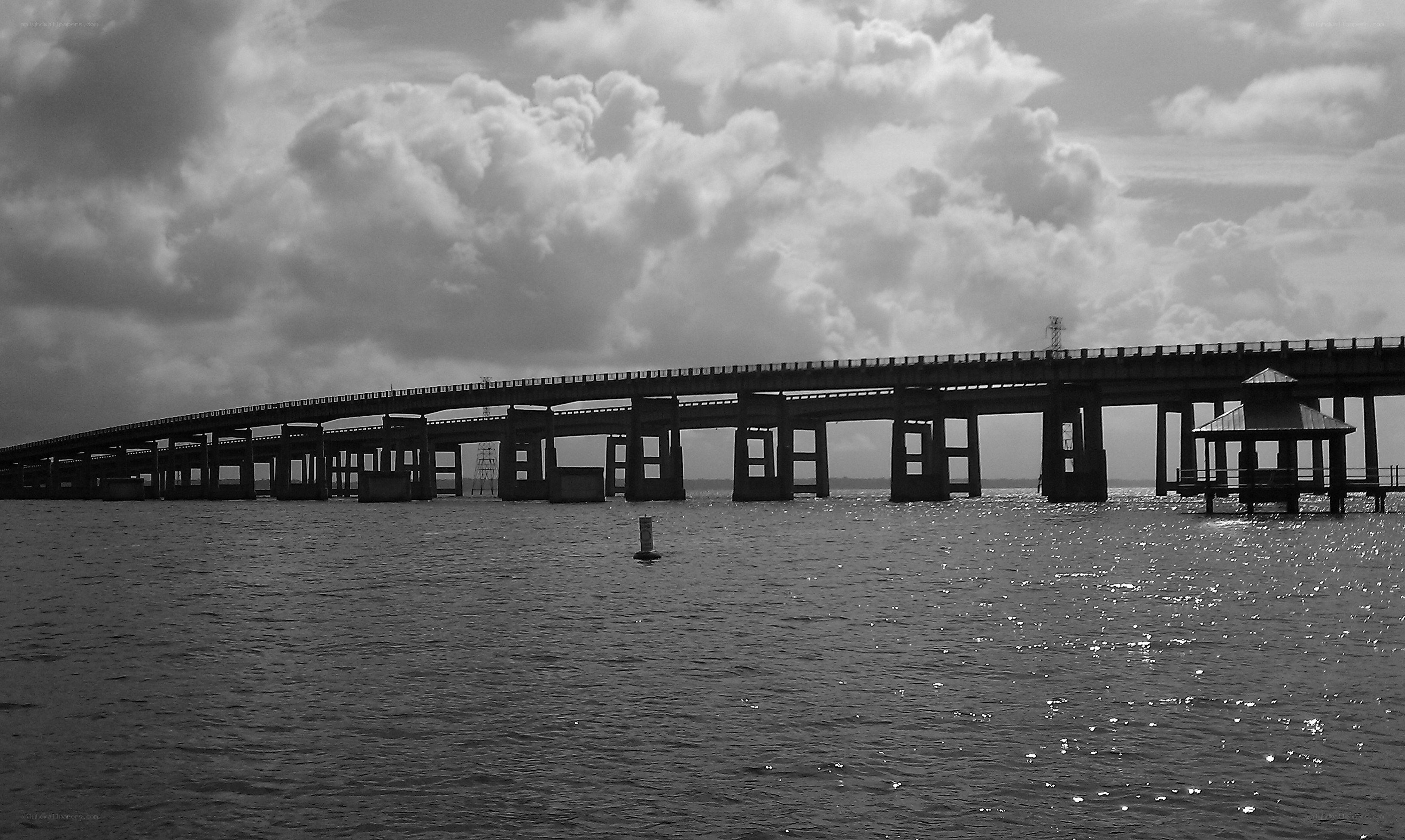 Bridge over water under cloudy sky
