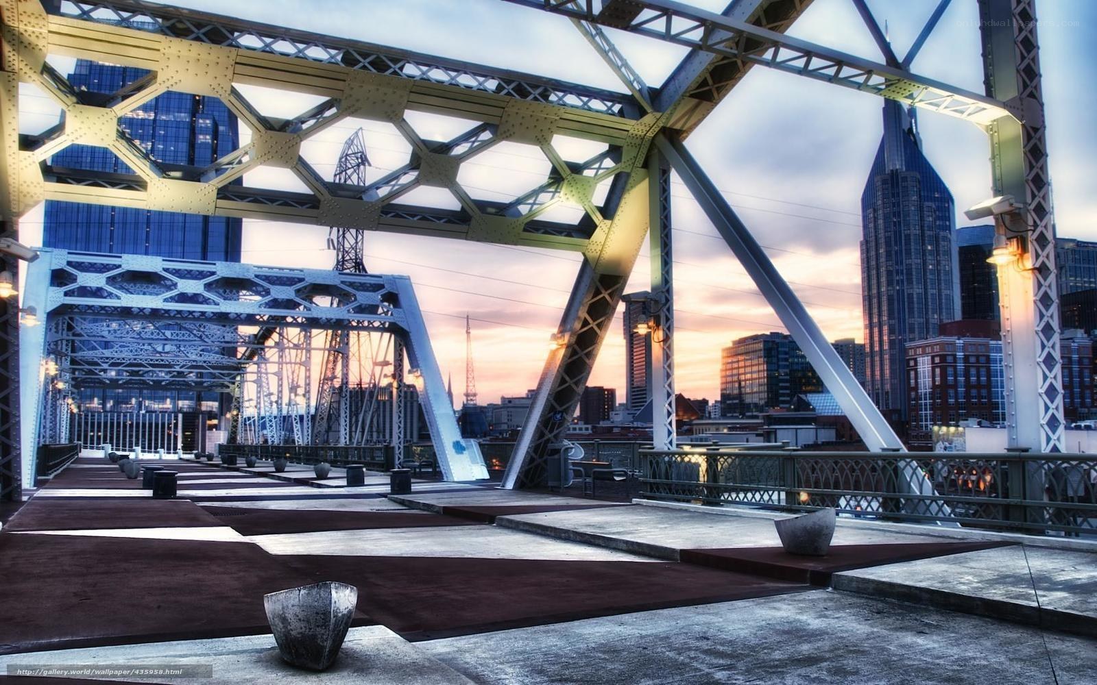 Bridge with city skyline at sunset