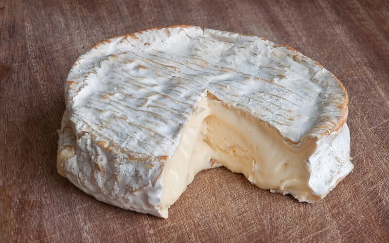 Brie cheese wheel with slice removed