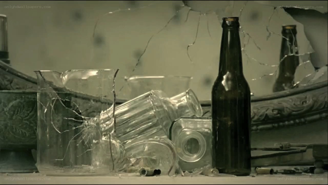 Broken glass and bottle on table