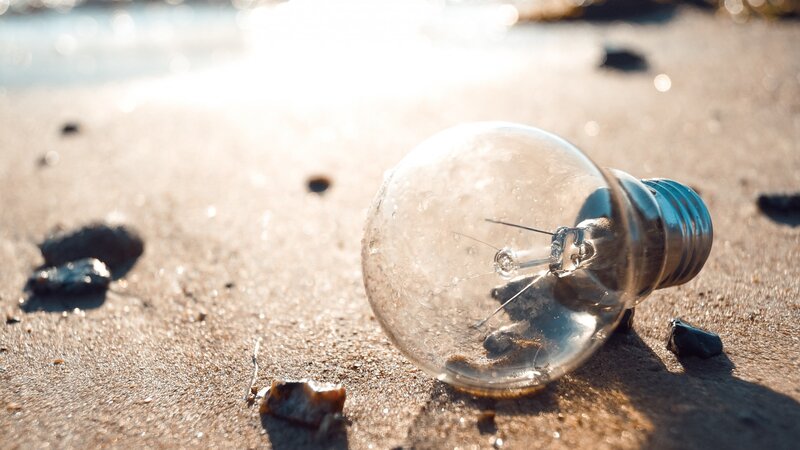 Broken Light Bulb on Sand