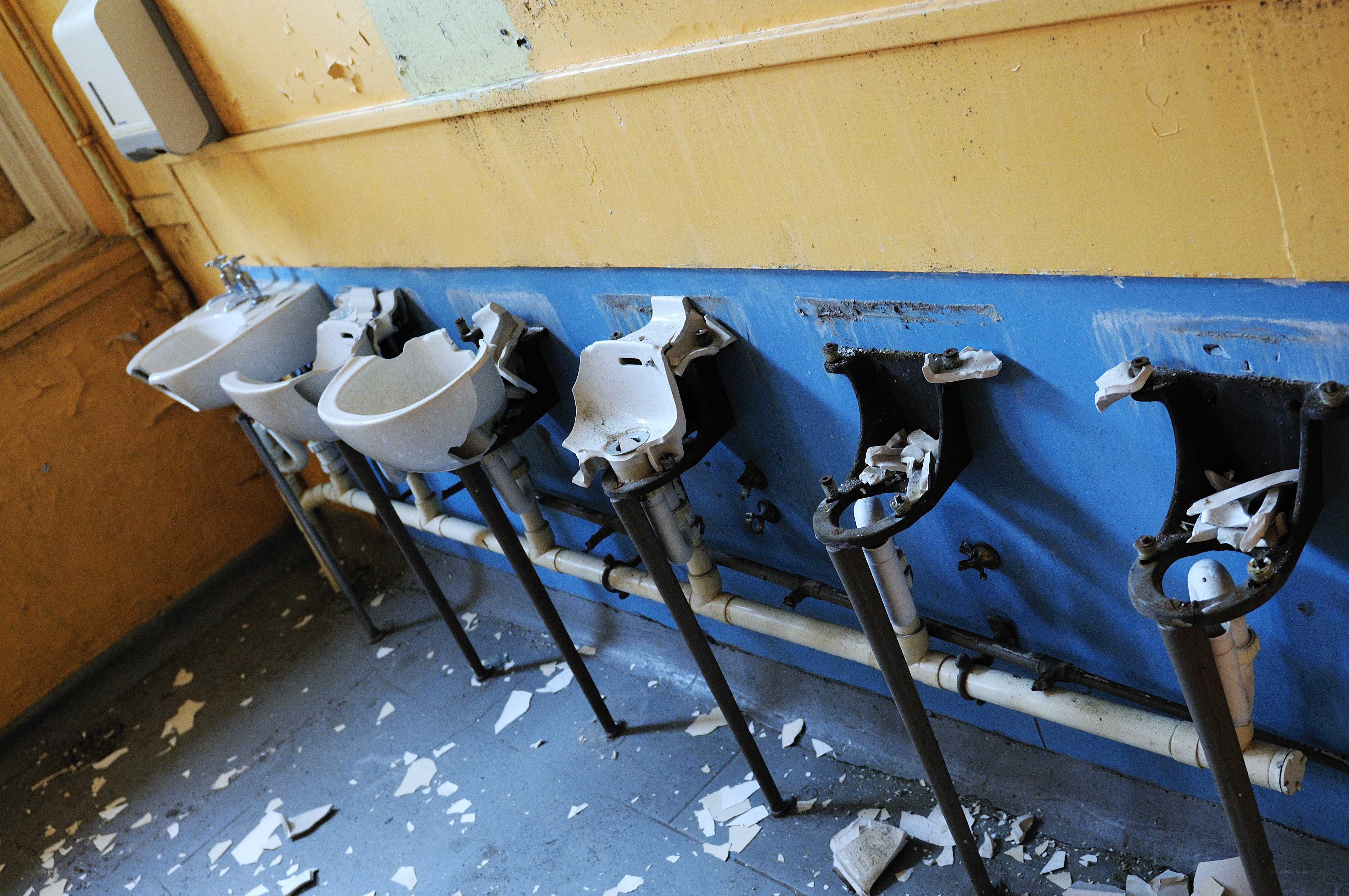Broken sinks in abandoned bathroom