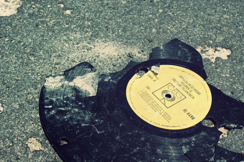 Broken vinyl record on pavement