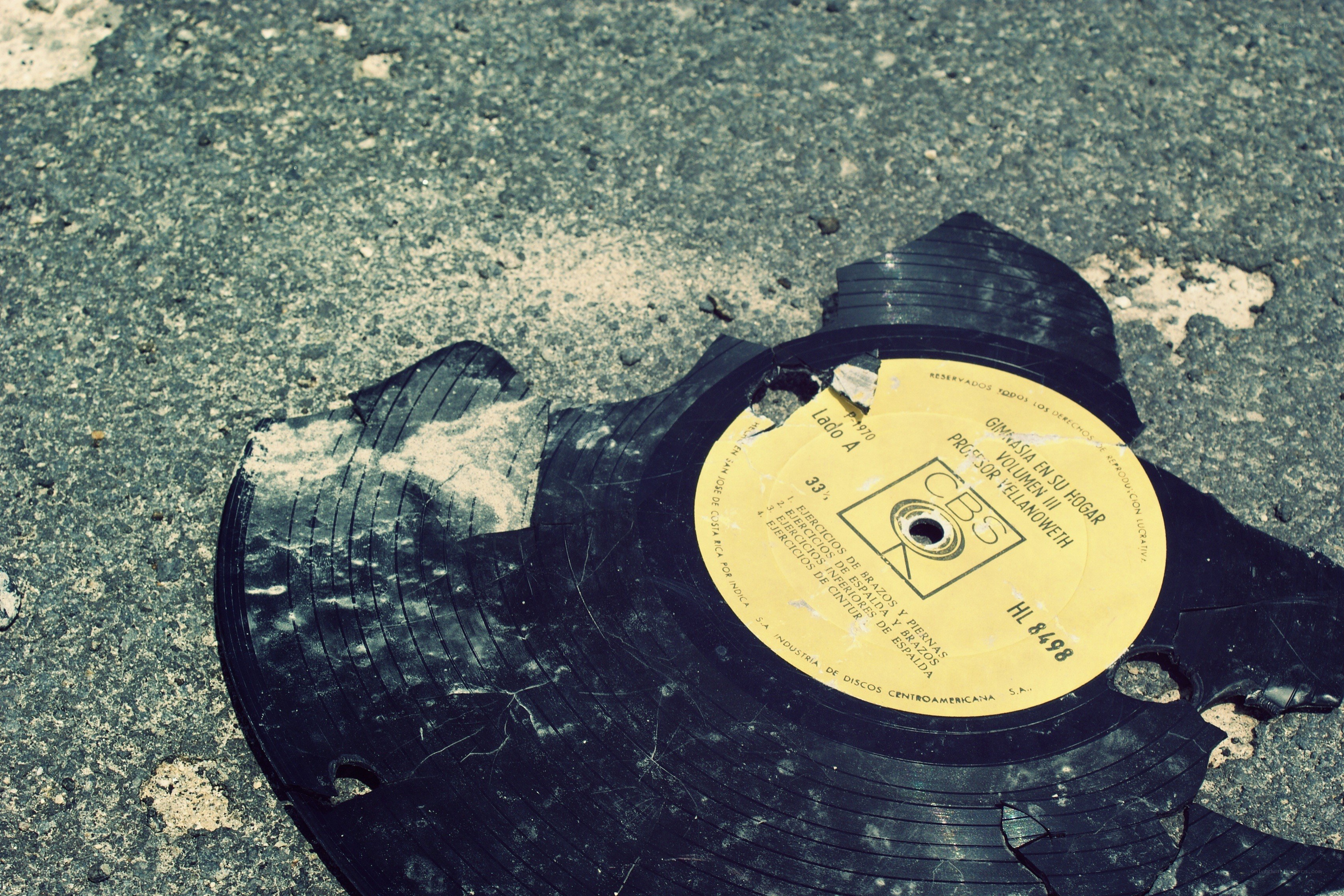 Broken vinyl record on pavement