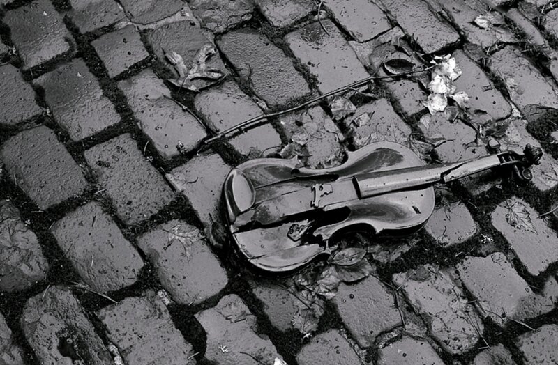 Broken Violin on Cobblestones