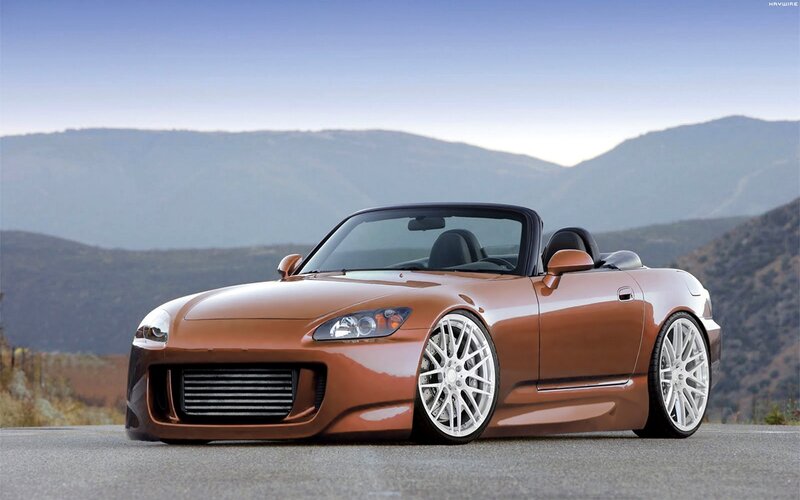 bronze sports car on mountain road