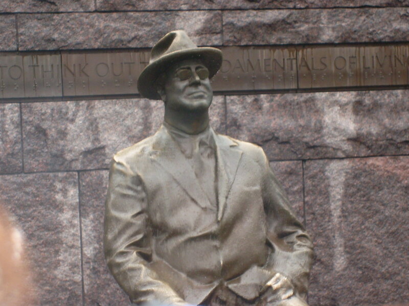bronze statue of man in hat