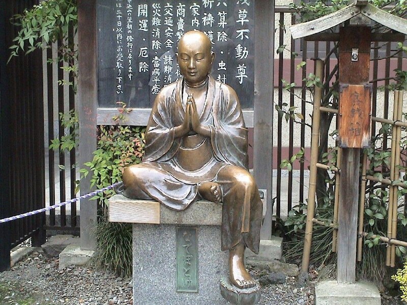 Bronze statue of monk in prayer