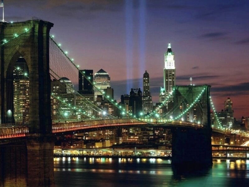 Brooklyn Bridge at night with light beams