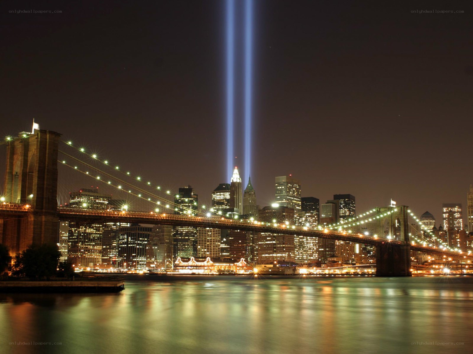 Brooklyn Bridge at night with light beams