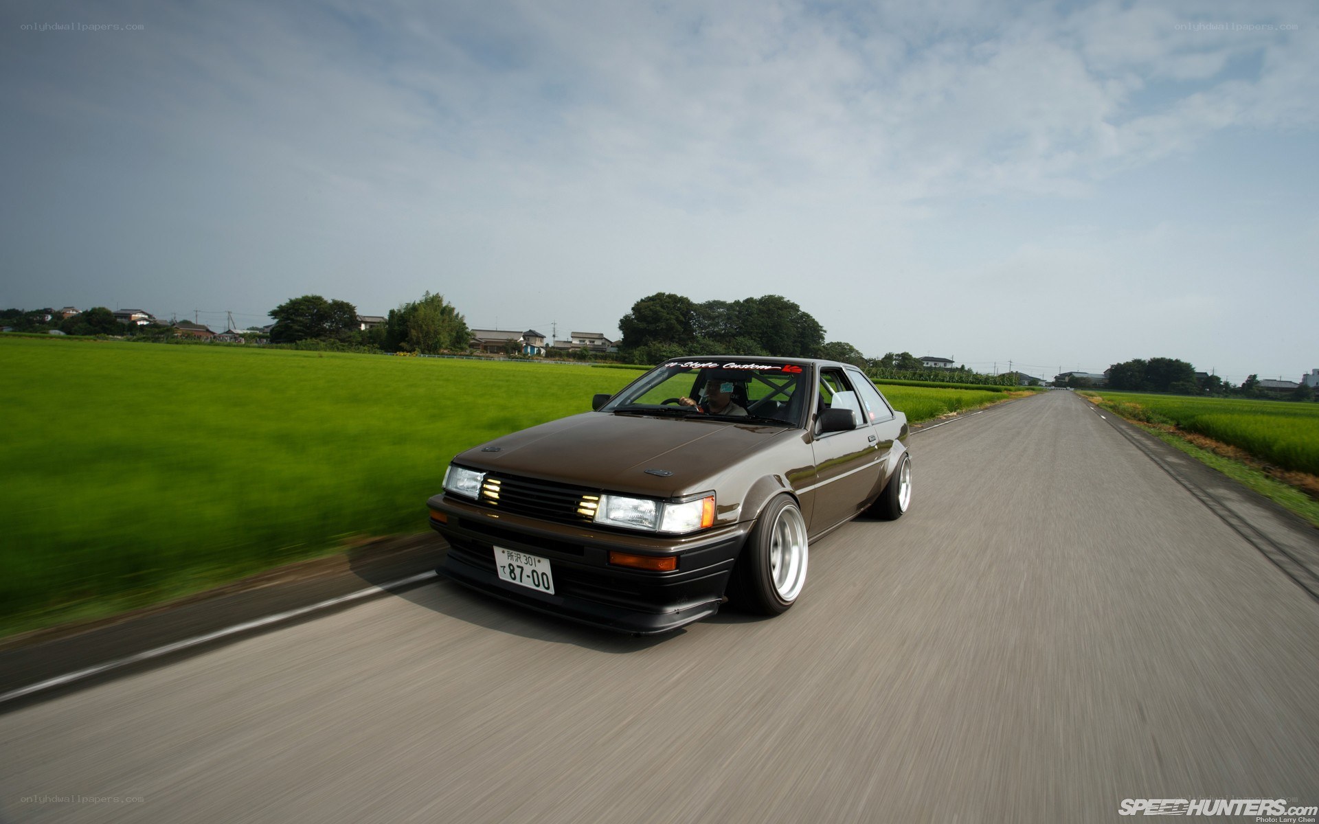 brown ae86 on rural road