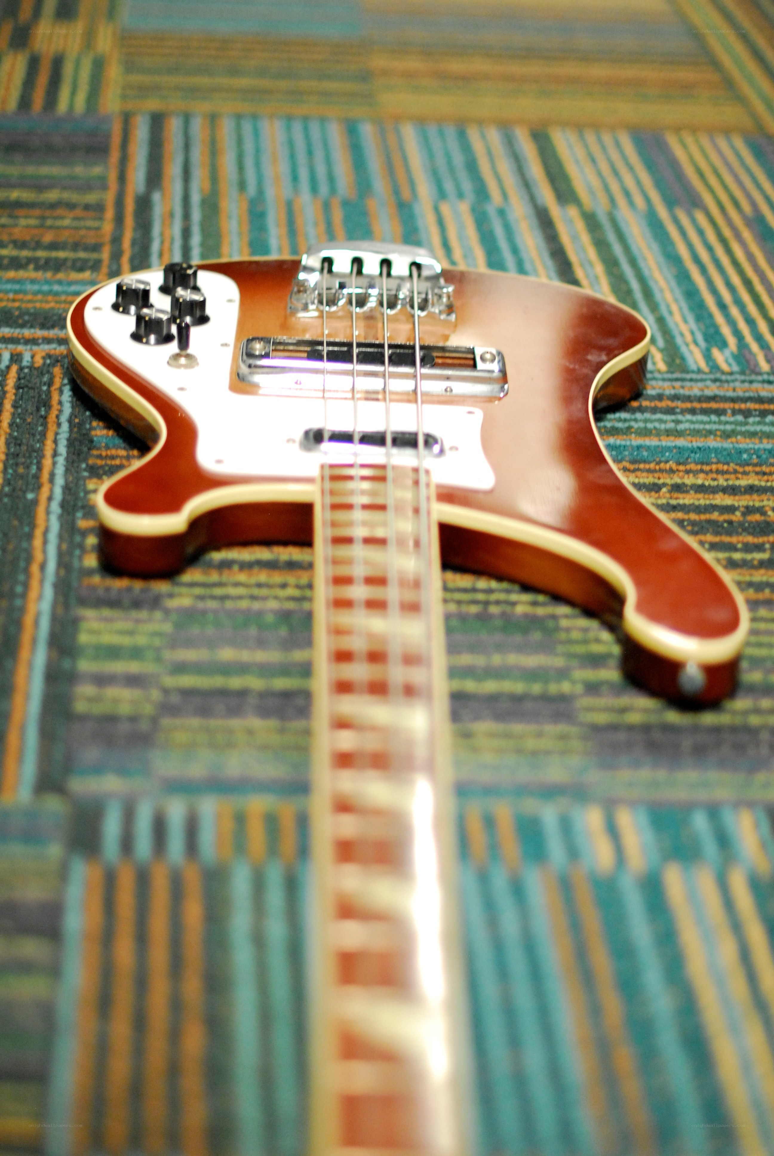 brown bass guitar on carpet