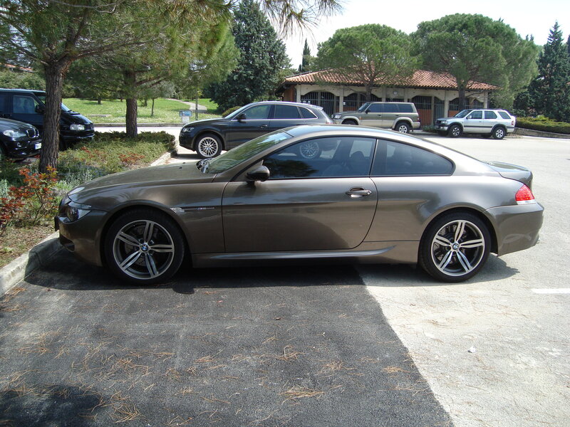 brown bmw coupe in parking lot