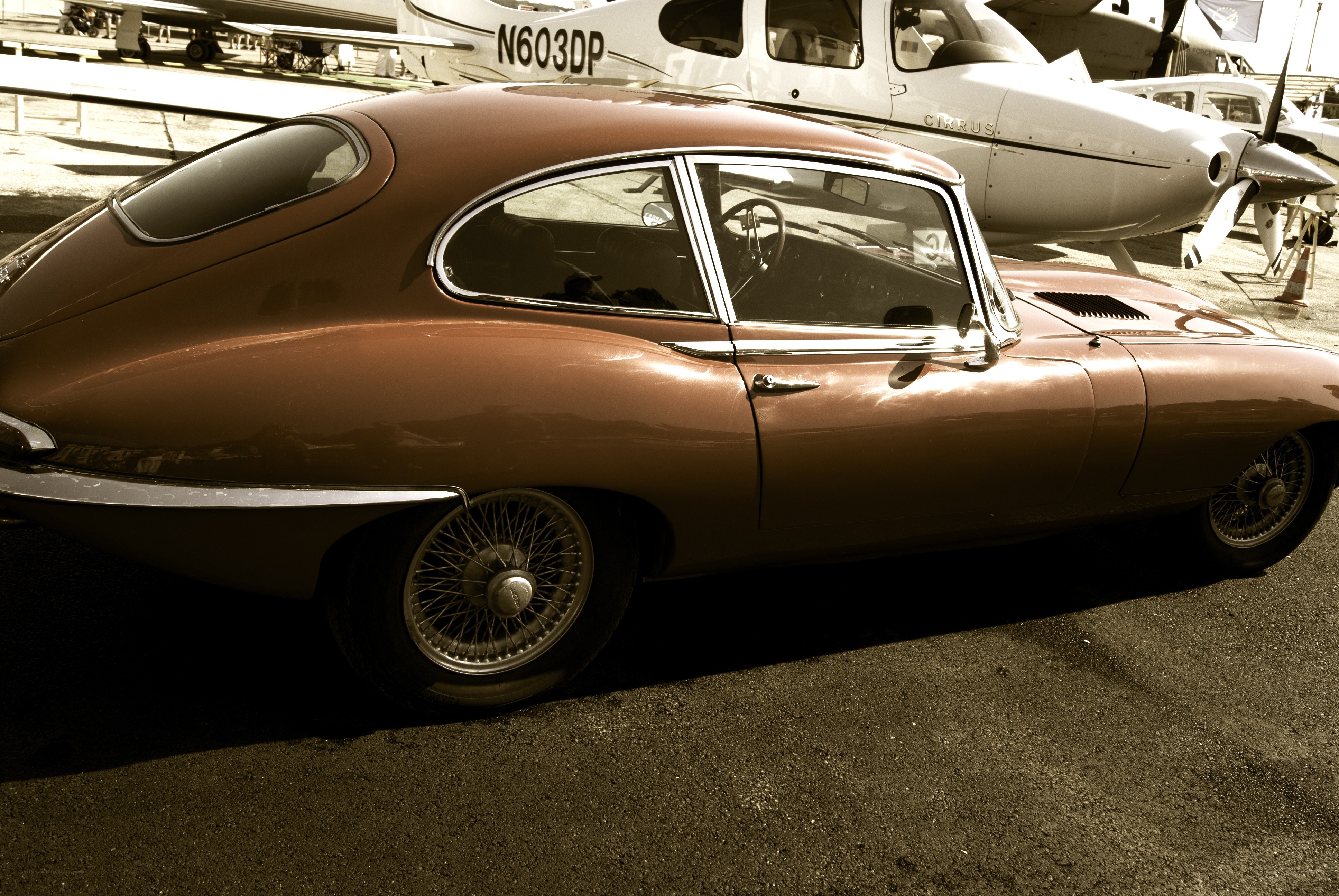 Brown classic car with airplane