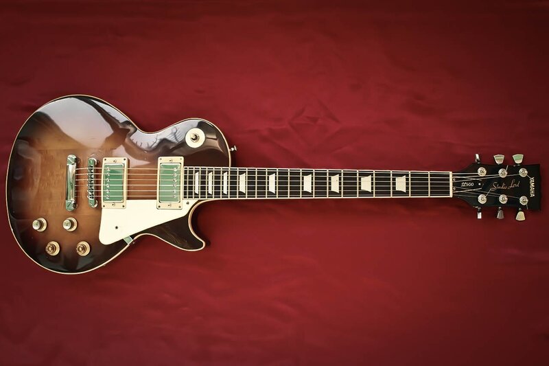 brown electric guitar on red