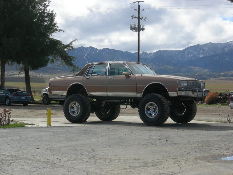 brown lifted car in parking lot