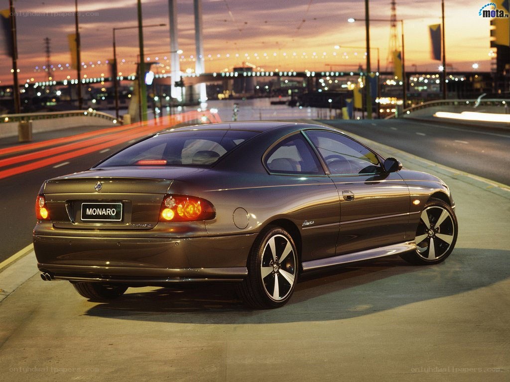 Brown Monaro on a city bridge