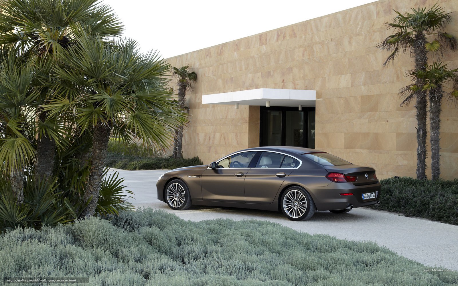 Brown sedan by modern building