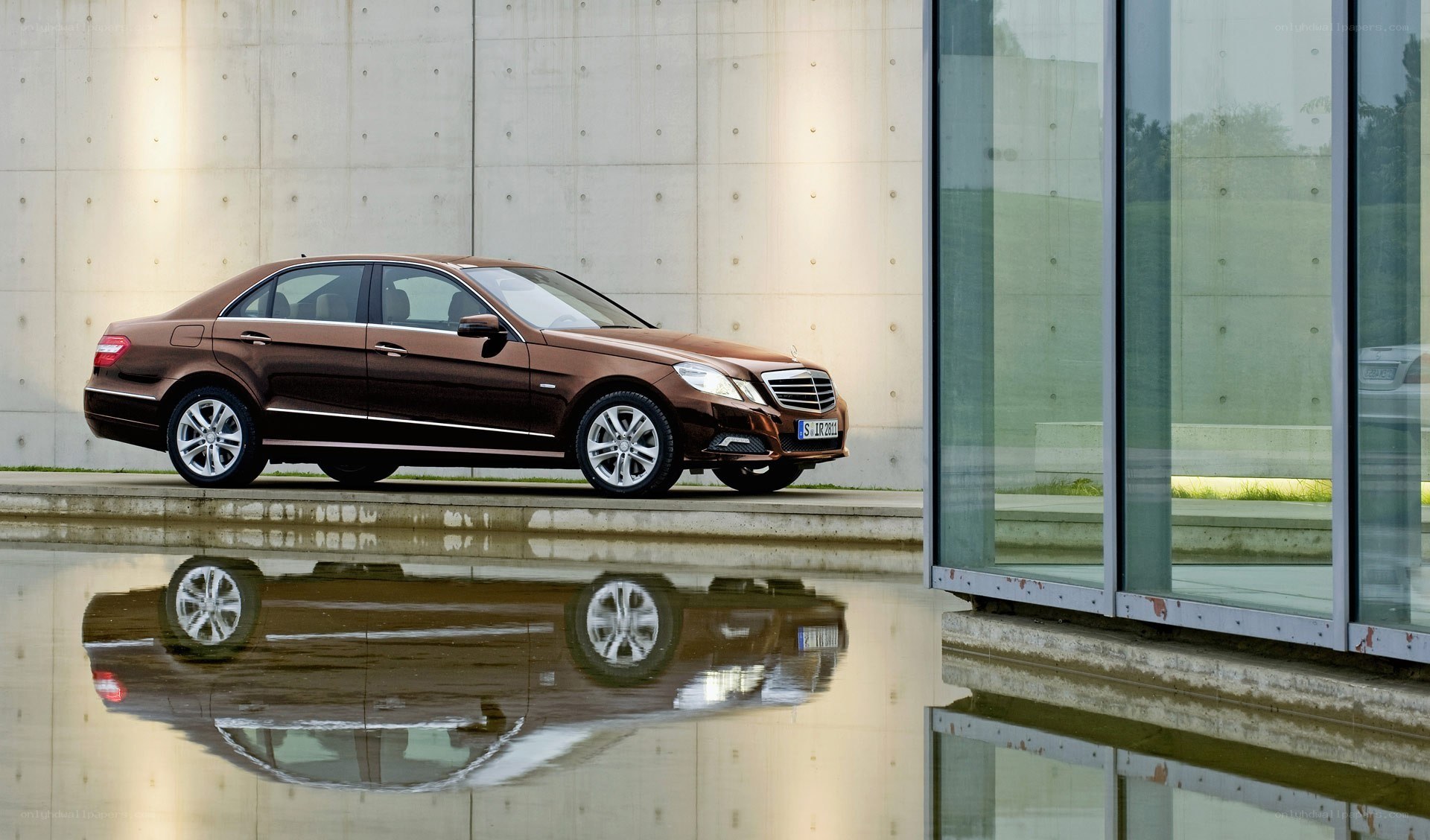 Brown sedan by water reflection