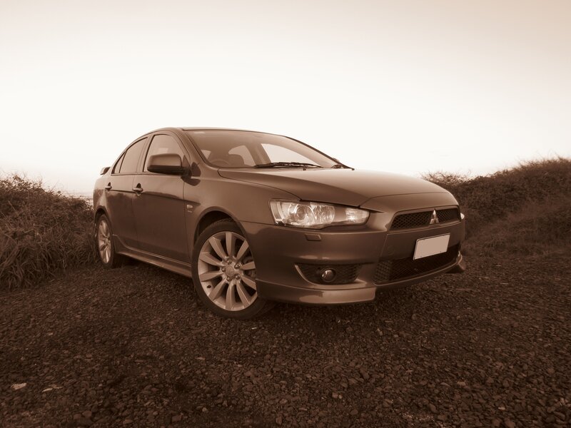 Brown sedan on gravel