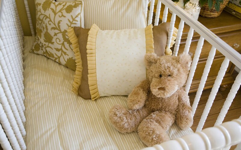 Brown Teddy Bear in Crib