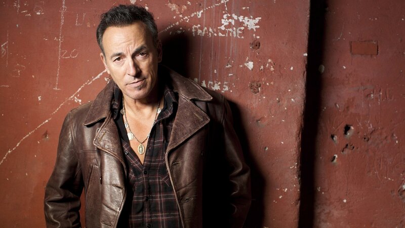 Bruce Springsteen against red wall