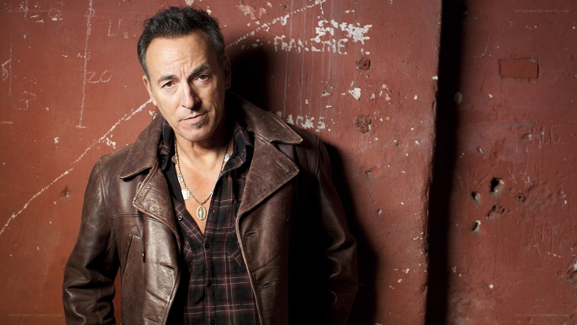 Bruce Springsteen against red wall