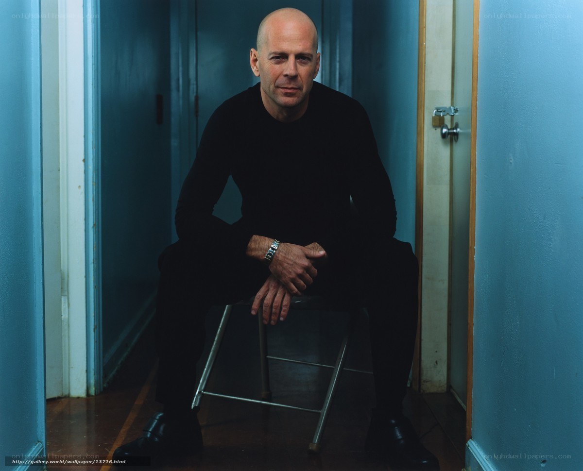 Bruce Willis sitting in a hallway