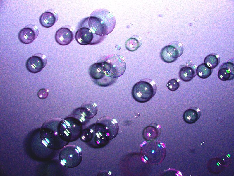 Bubbles floating in purple light