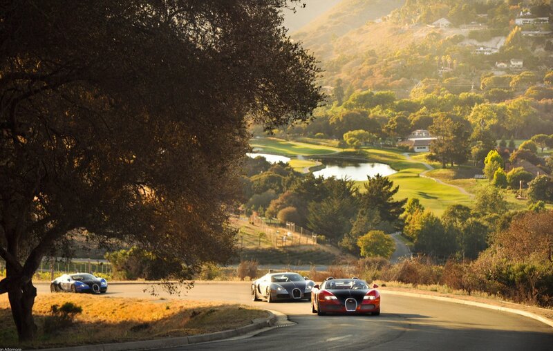 Bugatti cars on a scenic road
