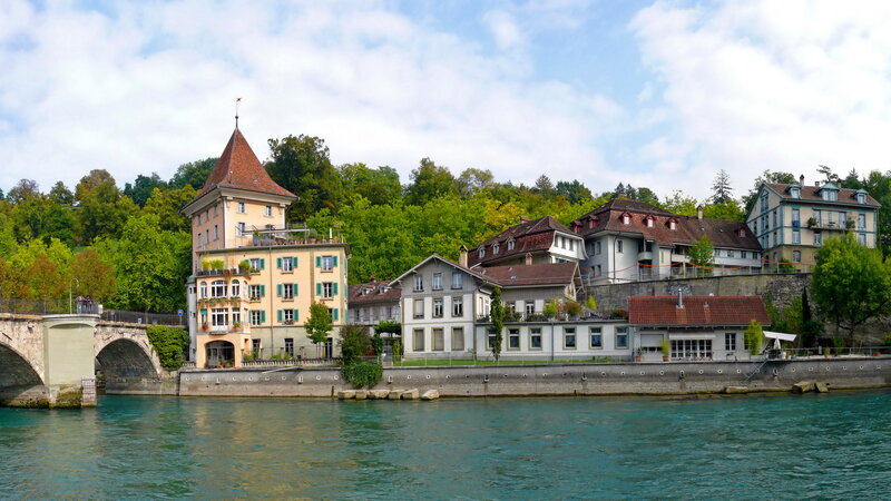 Buildings Along Riverbank — Blue, Serene, Afternoon