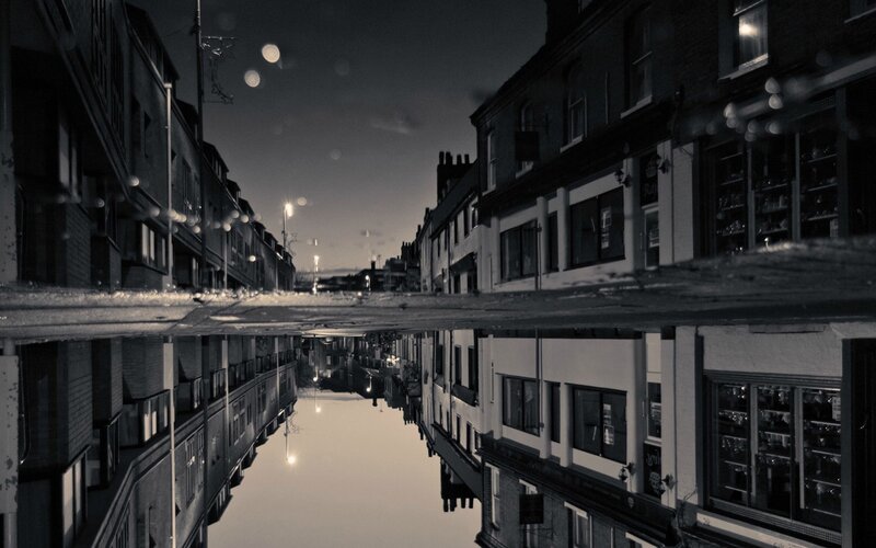 Buildings Reflected in Puddle