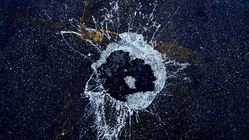 Bullet hole in asphalt
