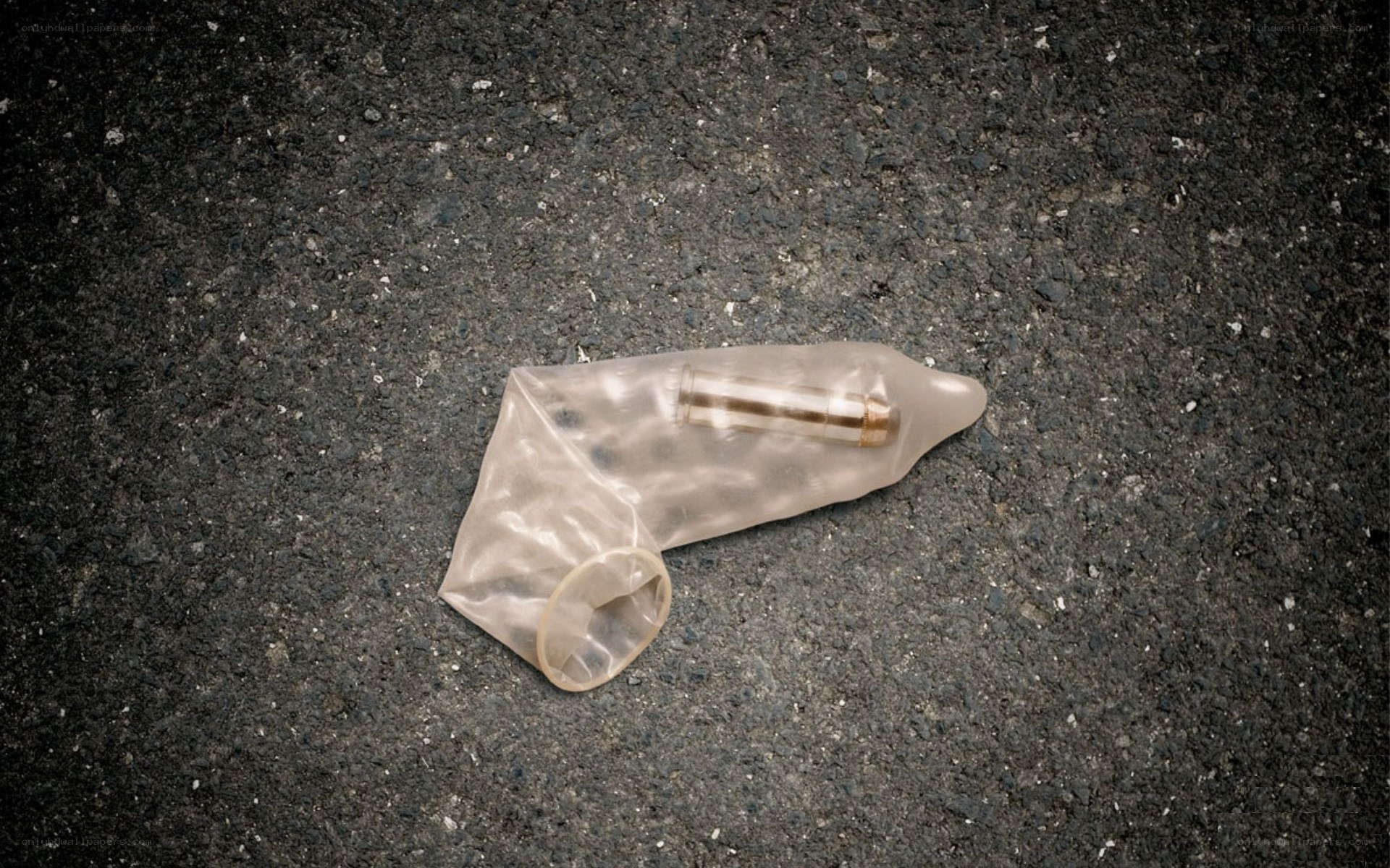 Bullet in a condom on pavement