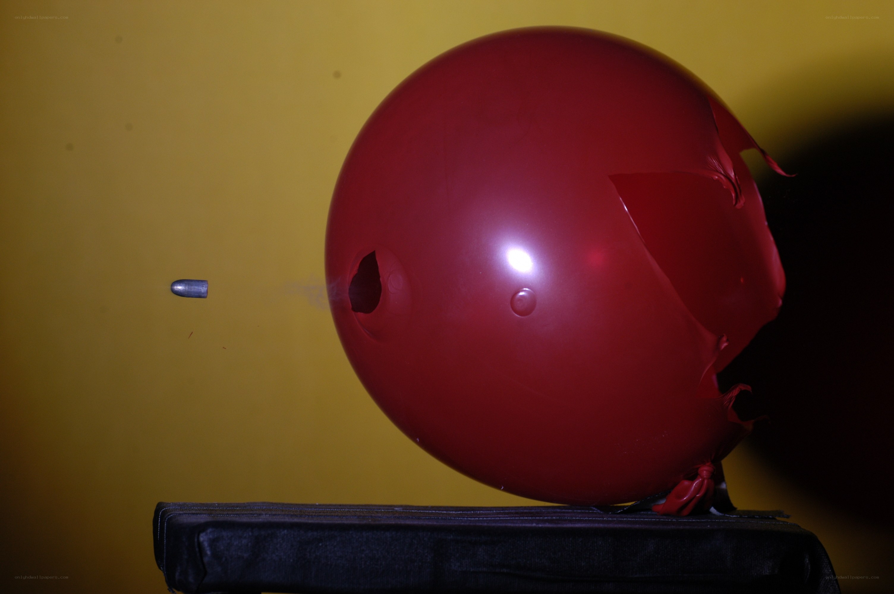 Bullet piercing red balloon