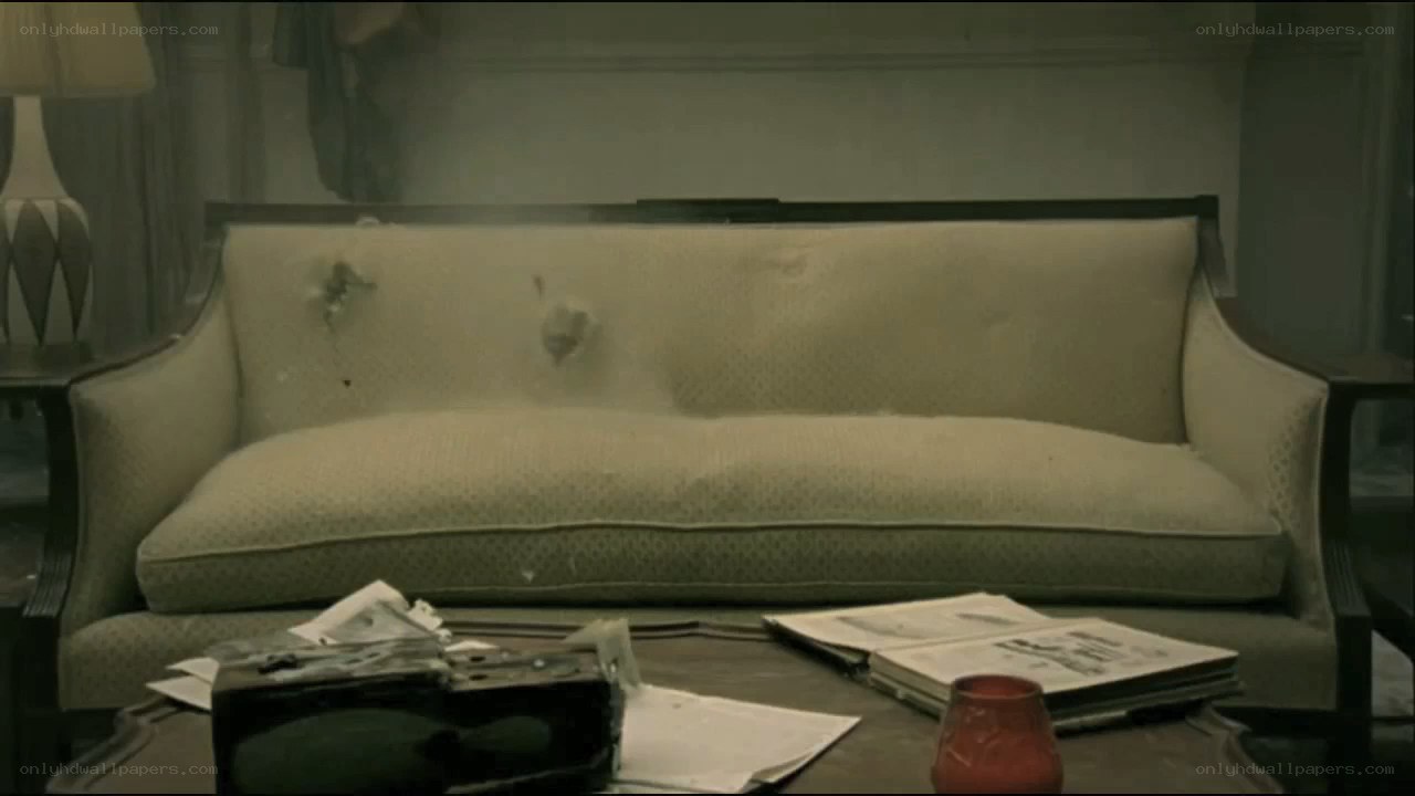 bullet-riddled couch in damaged room