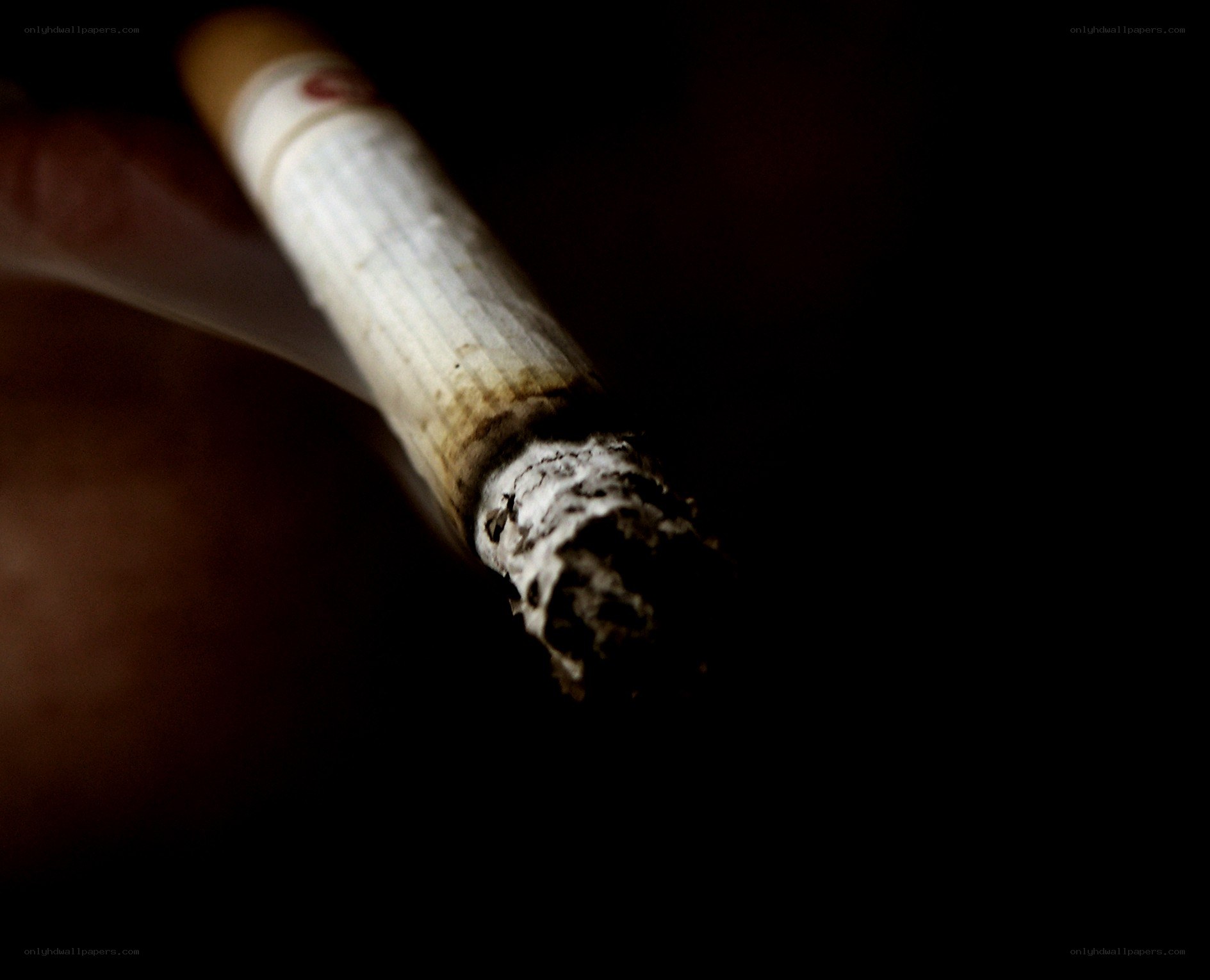burning cigarette in hand