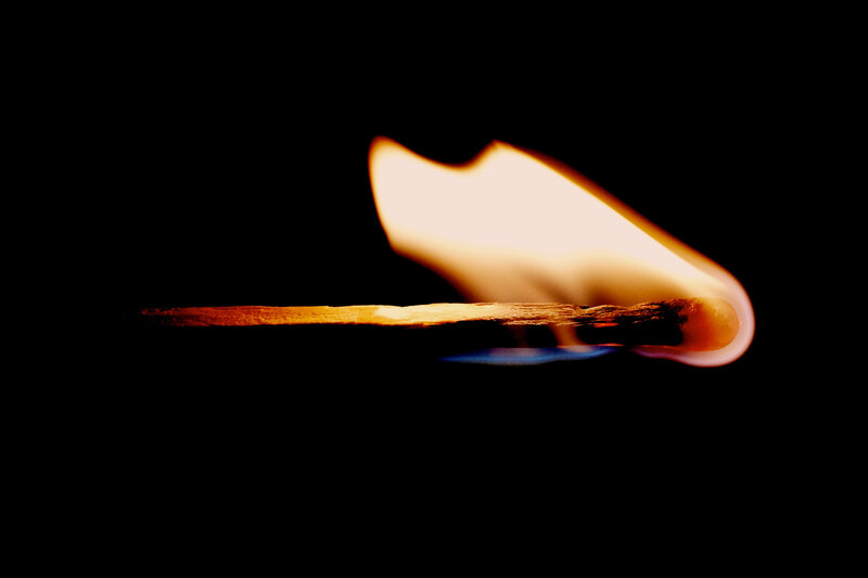 Burning match in darkness