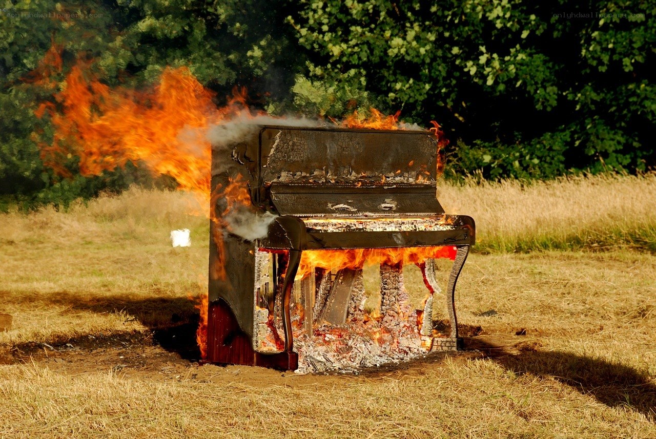 Burning piano in a field