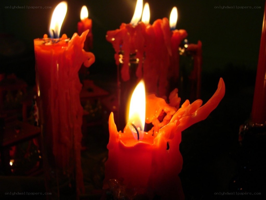 Burning red candles in darkness