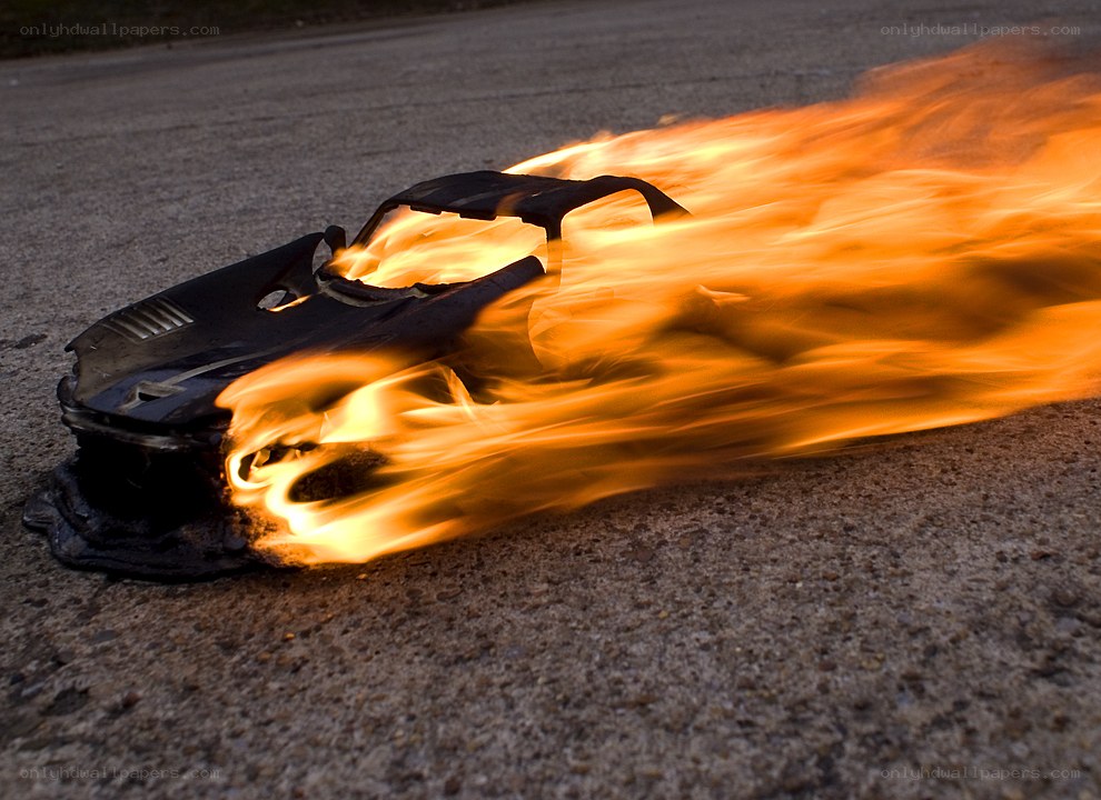 burning toy car on pavement