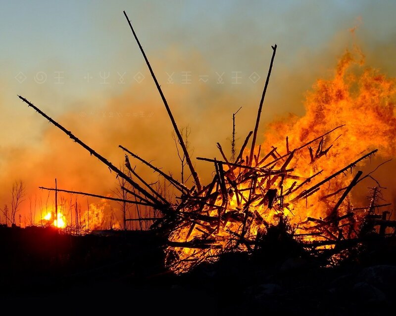 Burning wood pile at sunset