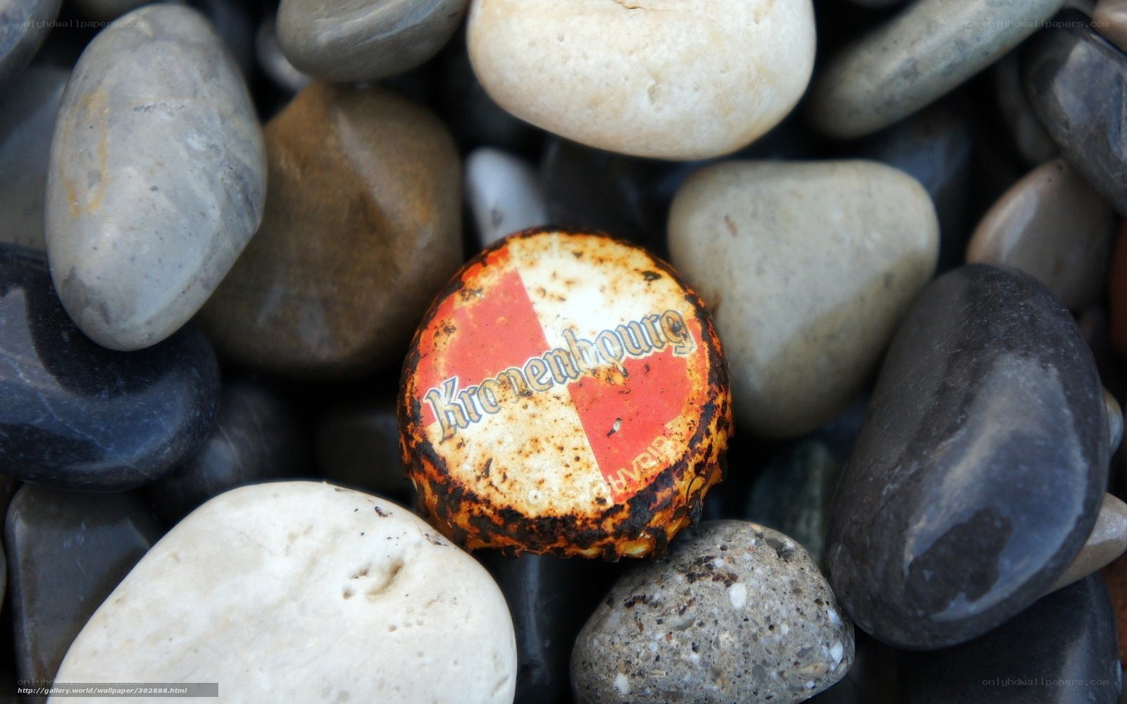 Burnt bottle cap among pebbles